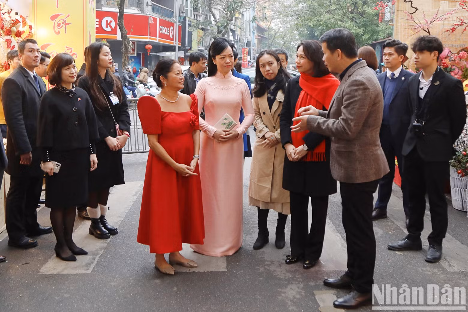 越南国家主席夫人和菲律宾总统夫人倾听有关梳街传统花市的介绍。