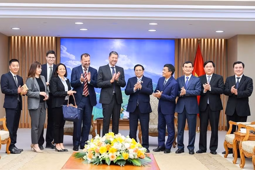 范明正总理同阿迪达斯集团首席执行官卡斯帕·罗斯特与代表团团员。（图片来源：越通社）