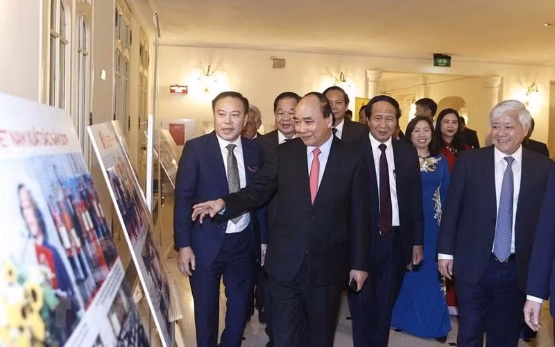 阮春福主席和与会代表参观表彰大会上展示的照片。（图片来源：越通社）