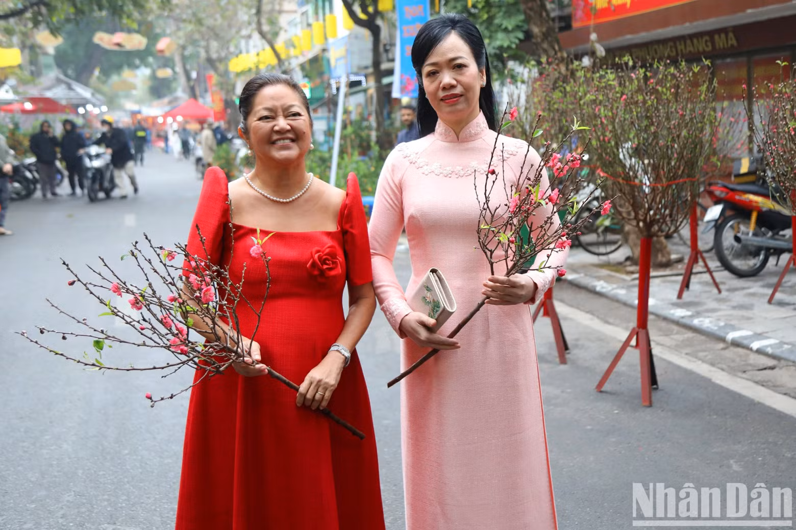 越南国家主席夫人和菲律宾总统夫人拿着桃花参观梳街传统花市。