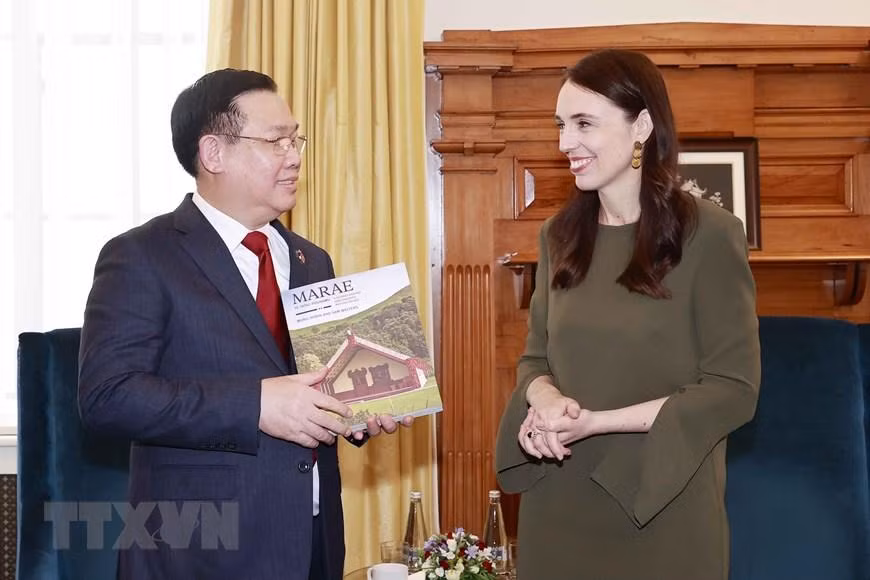 新西兰总理杰辛达·阿德恩向越南国会主席王廷惠赠送纪念品。（图片来源：越通社）