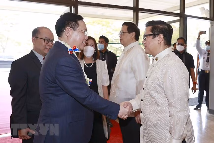 越南国会主席王廷惠与菲律宾众议员握手。
