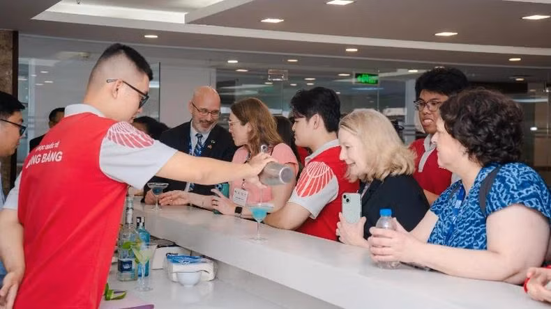 鸿庞大学酒店管理专业学生在实践课程中调制饮品，款待代表团。