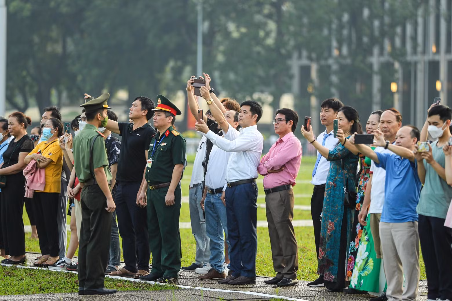 许多民众聚集在巴亭广场上亲眼见证国旗在风中飘扬。
