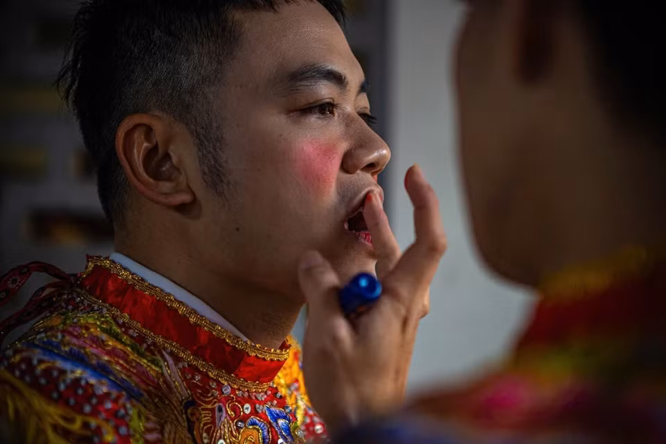 潮曲村腰鼓俱乐部成员涂上胭脂、男扮女装，准备参加腰鼓舞表演。