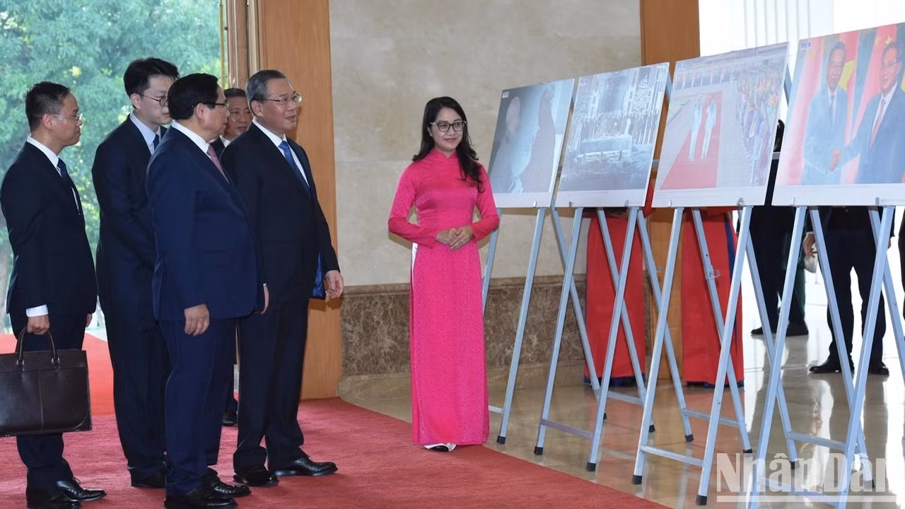越南政府总理范明正向中国国务院总理李强介绍有关越中合作的图片。