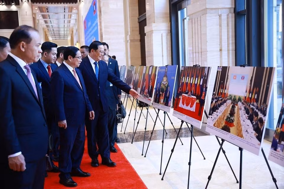 越南政府总理范明正与老挝政府总理宋赛·西潘敦共同参观两国合作图片展。