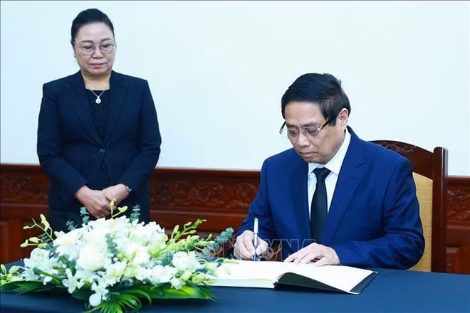 范明正总理在吊唁簿上题词。（图片来源：越通社）
