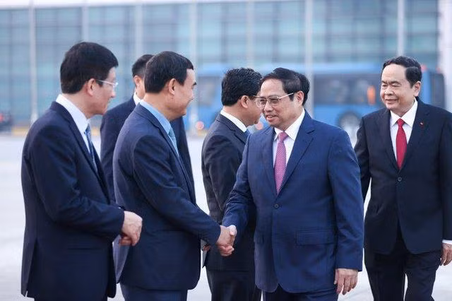 范明正总理与前来机场送行的官员握手。