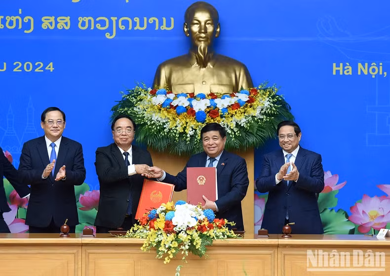 越南政府总理范明正与老挝政府总理宋赛·西潘敦见证越老政府间委员会第46次会议的合作纪要签订仪式。