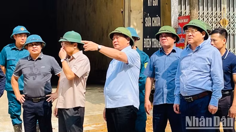阮春胜同志视察安沛市安宁坊的克服洪水、山体滑坡后果的情况。