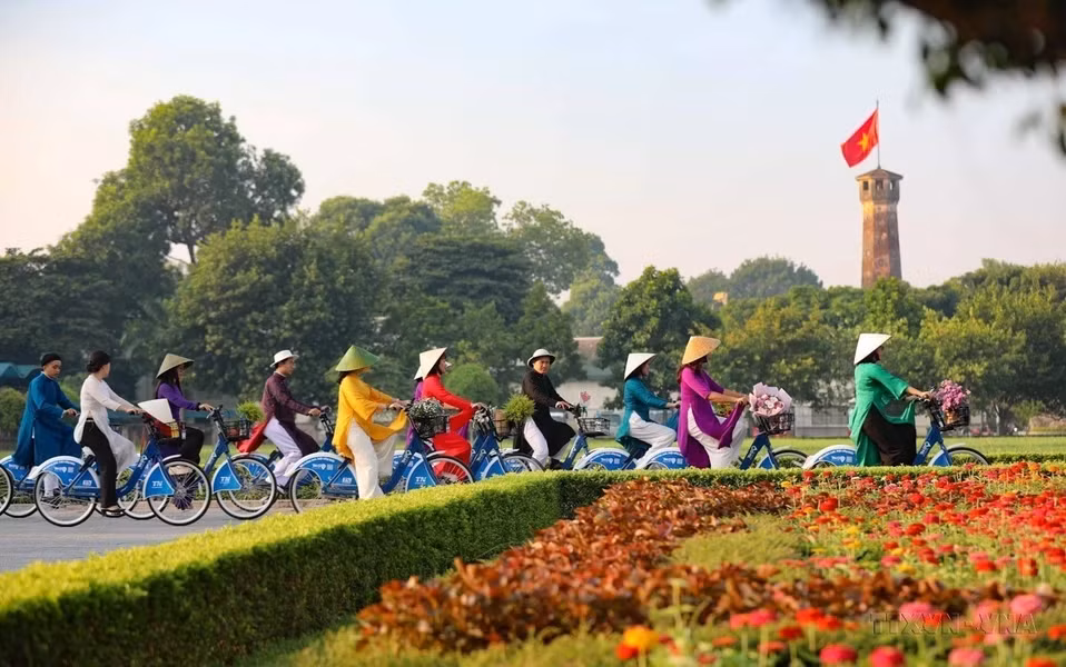 在2023年第一次“奥黛连接河内旅游与遗产”活动中，首都妇女在奠边府街上骑自行车，经过河内旗台。