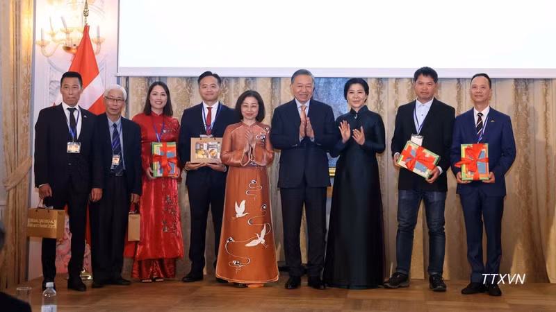 越共中央总书记、国家主席苏林和夫人吴芳璃向旅居丹麦、冰岛和瑞典南部越南人代表赠送礼品和越南语书籍。（图片来源：越通社）