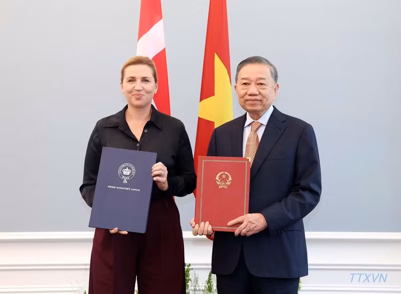 越共中央总书记、国家主席苏林和丹麦首相梅特·弗雷泽里克森互换关于建立越南与丹麦全面战略伙伴关系的联合声明文本。（图片来源：越通社） 