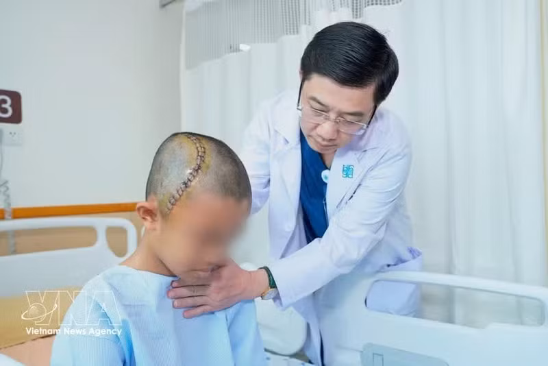 胡志明市医药大学附属医院神经外科主任张青情检查患者情况。（图片来源：越通社）