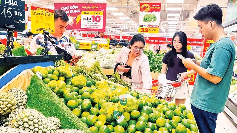 各大超市和门店加强对生活必需品的促销活动，以提振购买力，并在一定程度上分担消费者的成本压力。（武生 摄）