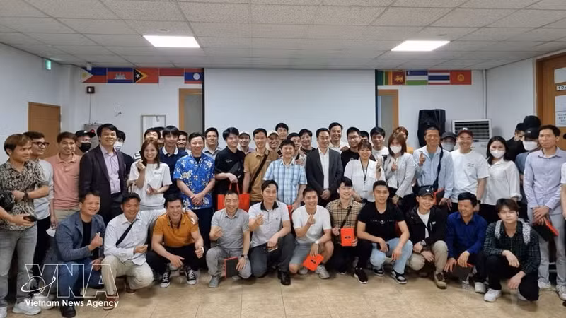在昌原（韩国）的越南劳动者与各组织方和赞助方代表在提高昌原越南劳动者法律知识咨询会上合影留念。（图片来源：越通社）