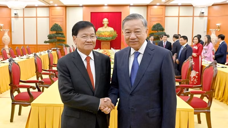越共中央总书记苏林与老挝人民革命党中央总书记、国家主席通伦·西苏里亲切握手合影。