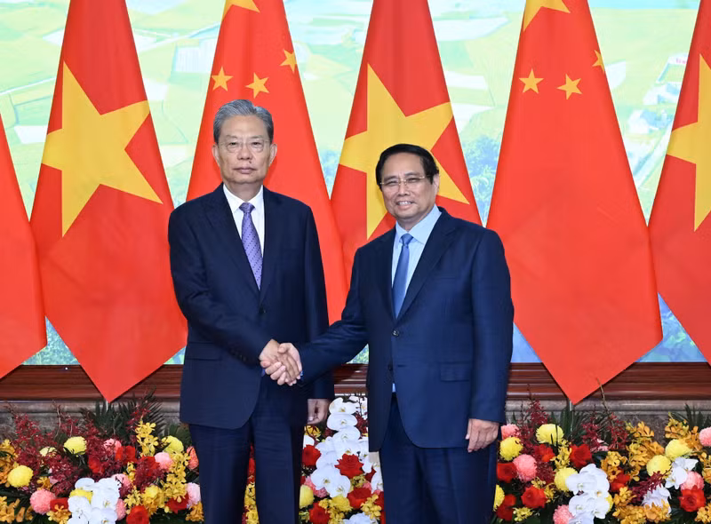 越南政府总理范明正与中共中央政治局常委、中国全国人大常委会委员长赵乐际亲切握手合影。