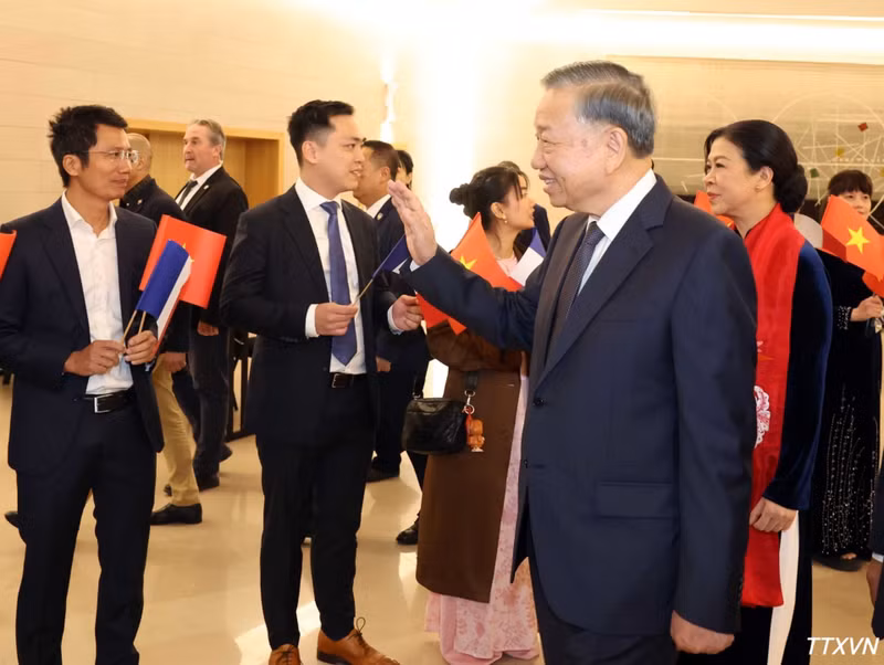越南驻法国大使馆干部人员和旅居法国越南人社团代表迎接越共中央总书记、国家主席苏林和夫人。