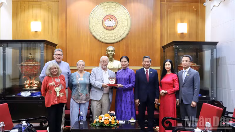 越南祖国阵线中央委员会副主席何氏娥向英国共产党总书记罗伯特·格里菲思赠送纪念品。